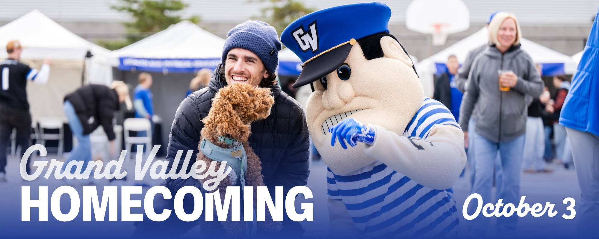 Alum holds dog with Louie at tailgate Homecoming October 3
